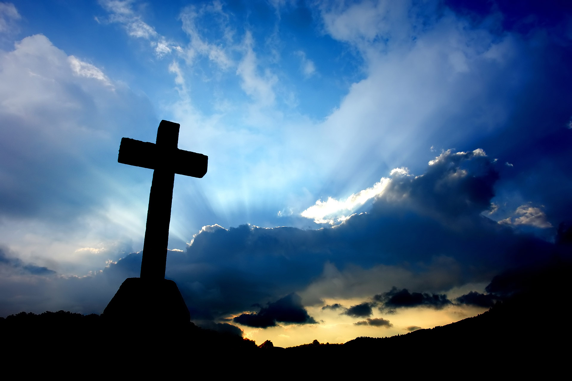 cross detail in silhouette and the clouds in the sky